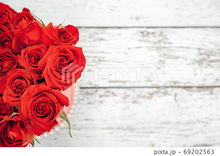 A bouquet of scarlet roses for Valentine's day ornaments concept with white wooden background. Love and romance concept. 69202563