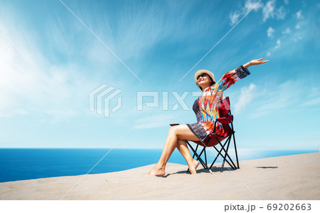 Beautiful sitting woman enjoying the idyllic scene of the sun, sand and sea. Beautyful sandy Patara beach in Antalya.  69202663