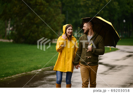 Love couple with umbrellas walks in park, back view 69203058
