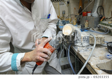 Worker cutting wooden blank with a hand cutting Worker cutting wooden blank with a hand cutting 69203355