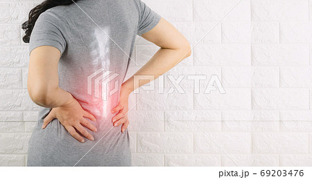 A woman holding the waist with pain spine bone A woman holding the waist with pain spine bone 69203476