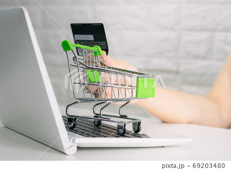 Hands holding credit card on the keyboard online shopping on lap Hands holding credit card on the keyboard online shopping on lap 69203480