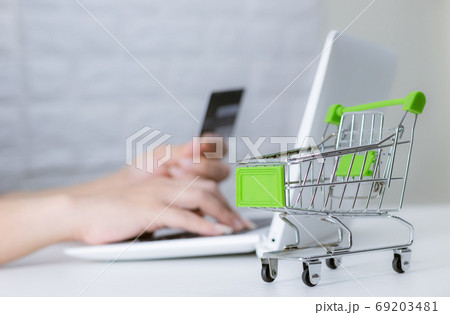 Hands holding credit card on the keyboard online shopping on lap Hands holding credit card on the keyboard online shopping on lap 69203481