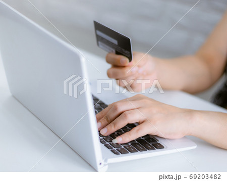 Hands holding credit card on the keyboard online shopping on lap Hands holding credit card on the keyboard online shopping on lap 69203482