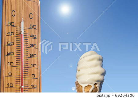 夏のイメージ＿真夏　温度計と溶けかけのソフトクリーム 69204306