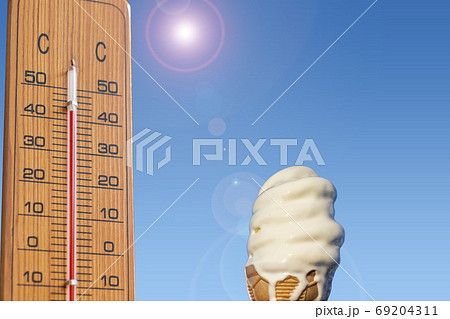 夏のイメージ＿真夏　温度計と溶けかけのソフトクリーム 69204311