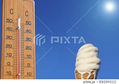 夏のイメージ＿真夏　温度計と溶けかけのソフトクリーム 69204312