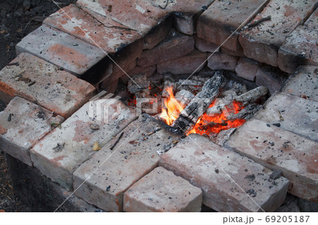 Fire wood, coal and amber ash closeup. Red tongues of flame and glowing amber. Concept of home and warmth. Close up shot of burning firewood in the fireplace. 69205187