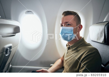 Man wearing face mask inside airplane Man wearing face mask inside airplane 69205910