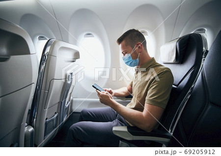 Man wearing face mask inside airplane Man wearing face mask inside airplane 69205912