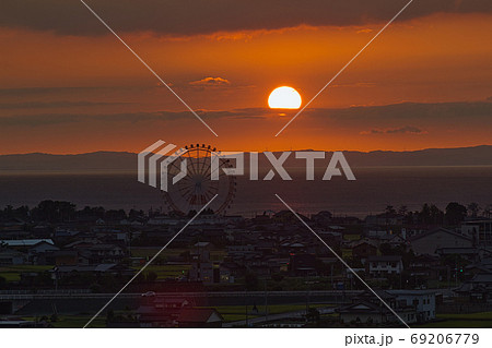 夕方の有磯海サービスエリアから見る観覧車と富山湾ごしの夕日 69206779