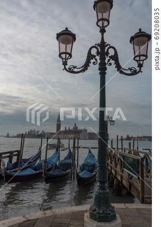 海上のサン・ジョルジョ・マッジョーレ聖堂と係留された青い幌のゴンドラ・ベネチア 69208035