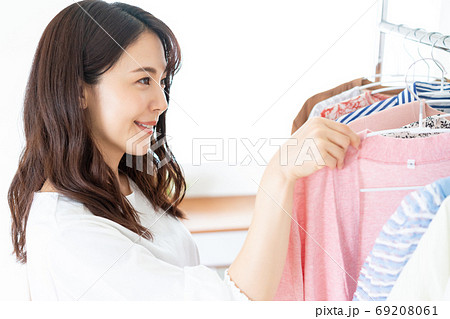 服を選ぶ笑顔の若い女性 69208061
