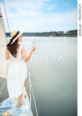 woman with glass of champagne resting on yacht 69208524