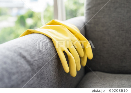 Cleaning yellow gloves on sofa. Hygiene service concept Cleaning yellow gloves on sofa. Hygiene service concept 69208610