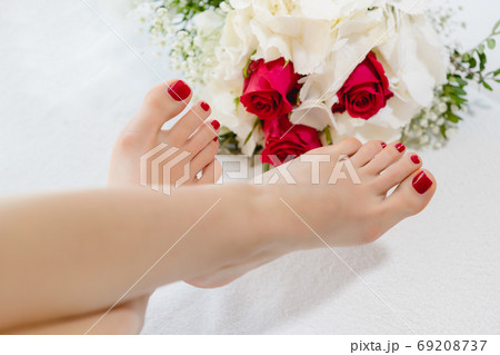 Feet of women with red toenails after pedicure 69208737