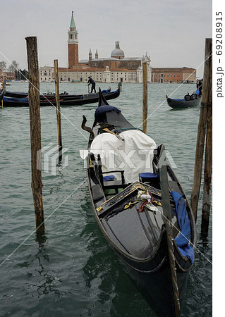 海上のサン・ジョルジョ・マッジョーレ聖堂と係留された青い幌のゴンドラ・ベネチア 69208915