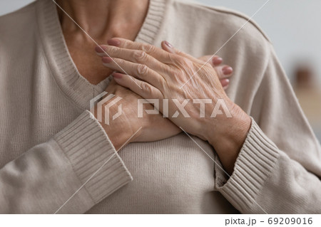 Close up hopeful grateful mature woman keeping hands on chest Close up hopeful grateful mature woman keeping hands on chest 69209016