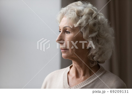 Close up upset thoughtful mature senior woman looking out window 69209131