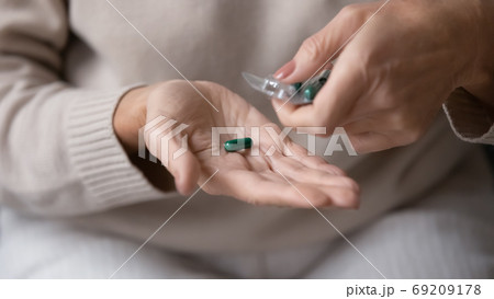 Close up mature woman taking pill out of packaging 69209178