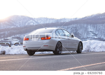 休日 ドライブ セダン 輸入車 白い車 山道の写真素材