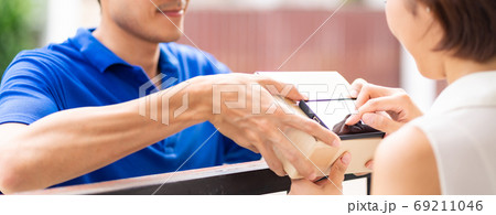 Panoramic asian customer woman sign for recieve package delivery 69211046