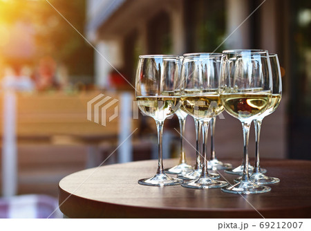White wine tasting on winery terrace, pouring of cold dry wine in glasses outdoor in sunny day 69212007