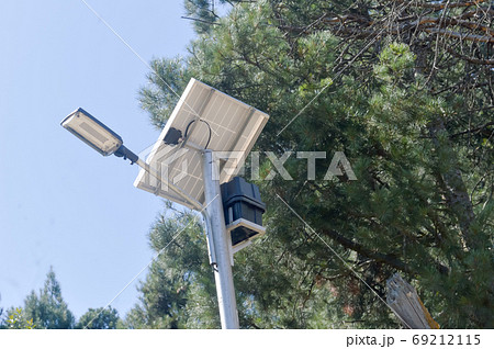 Photovoltaic Waterproof Aluminium make Solar Light in pine tree and blue sky background. Photovoltaic Waterproof Aluminium make Solar Light in pine tree and blue sky background. 69212115