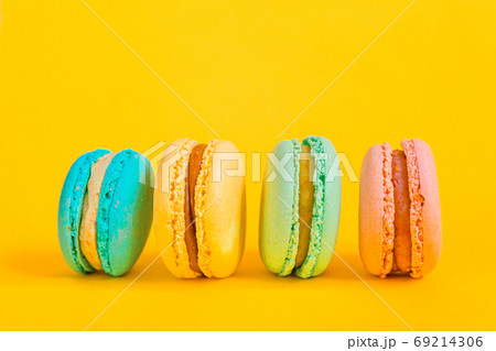 Sweet almond colorful unicorn pink blue yellow green macaron or macaroon dessert cake isolated on trendy yellow modern fashion background. French sweet cookie. Minimal food bakery concept Copy space Sweet almond colorful unicorn pink blue yellow green macaron or macaroon dessert cake isolated on trendy yellow modern fashion background. French sweet cookie. Minimal food bakery concept Copy space 69214306