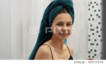 Happy woman in the bathroom with towel on her head Happy woman in the bathroom with towel on her head 69215038