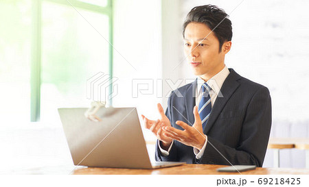 PCに向かってビデオチャットをしている男性 69218425