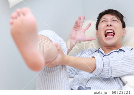 寝ている時急に足がつって辛い男性 69225221
