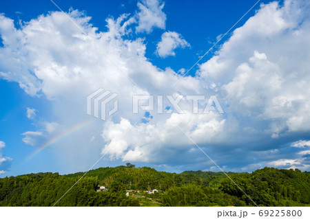 真夏の青空と虹 積乱雲 8月 背景素材 コピースペースの写真素材