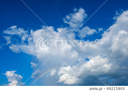 真夏の青空と虹 積乱雲 8月 背景素材 コピースペースの写真素材