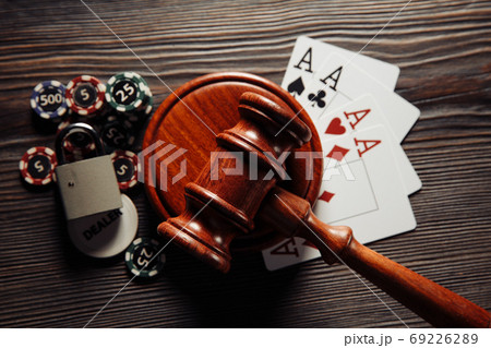 Judge's wooden gavel, poker chips and playing cards on wooden table. Concept of Law and regulation of gambling Judge's wooden gavel, poker chips and playing cards on wooden table. Concept of Law and regulation of gambling 69226289