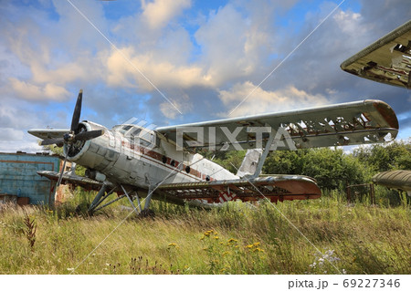 Airplane cemetery in the field against cloudy blue sky 69227346