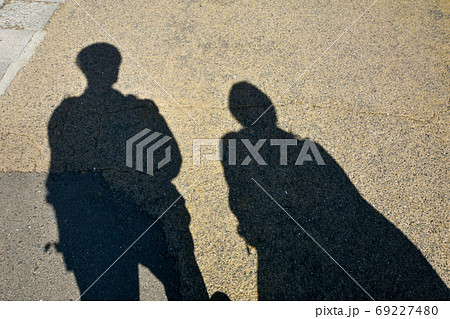 道を歩く代カップルの影の写真素材