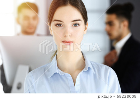 Business woman and group of diverse business people at the background in sunny office 69228009