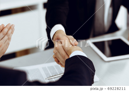 Business people shaking hands after contract signing in modern office. Teamwork and handshake concept Business people shaking hands after contract signing in modern office. Teamwork and handshake concept 69228211