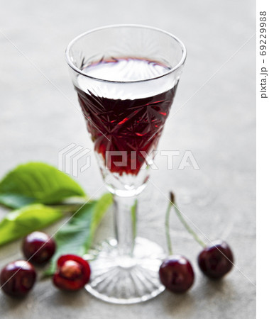 Cherry liqueur in a glass and fresh fruits Cherry liqueur in a glass and fresh fruits 69229988