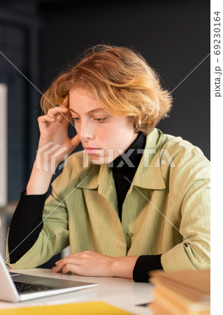 Young serious female developer of software looking through online information Young serious female developer of software looking through online information 69230164