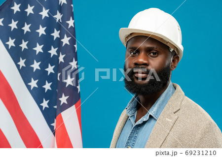 Young bearded African-american engineer in protective helmet and formalwear 69231210