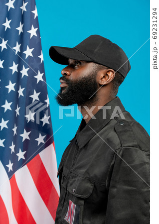 Side view of young bearded African-american male security in black uniform 69231294