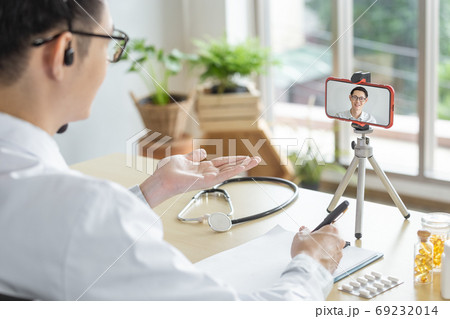 asian man patient In the screen smartphone. Online consultation speaking to patient . asian man patient In the screen smartphone. Online consultation speaking to patient . 69232014