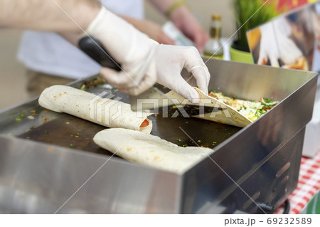 Hands in gloves, process of preparing a fajitas or fajitos, chef cooking, authentic street food. Concept of national food 69232589