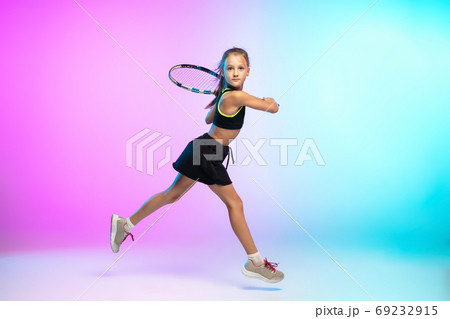 Little tennis girl in black sportwear isolated on gradient background in neon light 69232915