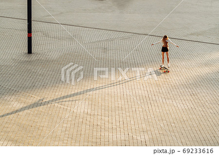 Longboarding in the evening city. Woman on a skateboard. 69233616