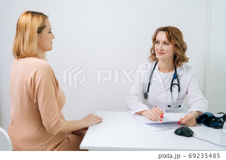 Happy young pregnant woman with blonde hair visiting doctor in prenatal clinic. Happy young pregnant woman with blonde hair visiting doctor in prenatal clinic. 69235485