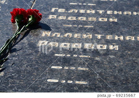 flowers on the memorial to fallen soldiers, red carnations on black marble, Russian text of soldiers military rank - sergeant,major, colonel,Lieutenant Colonel, private, corporal flowers on the memorial to fallen soldiers, red carnations on black marble, Russian text of soldiers military rank - sergeant,major, colonel,Lieutenant Colonel, private, corporal 69235667
