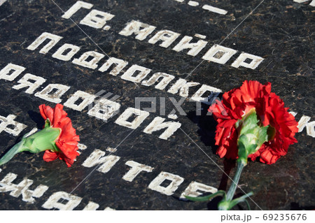 flowers on the memorial to fallen soldiers, red carnations on black marble, Russian text of soldiers military rank - sergeant,major, colonel,Lieutenant Colonel, private, corporal 69235676